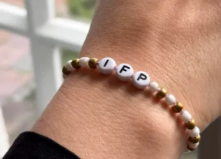 Das Symbolbild zeigt durch ein Armbändchen mit der Aufschrift "ifp" die Verbundenheit mit dem ifp.